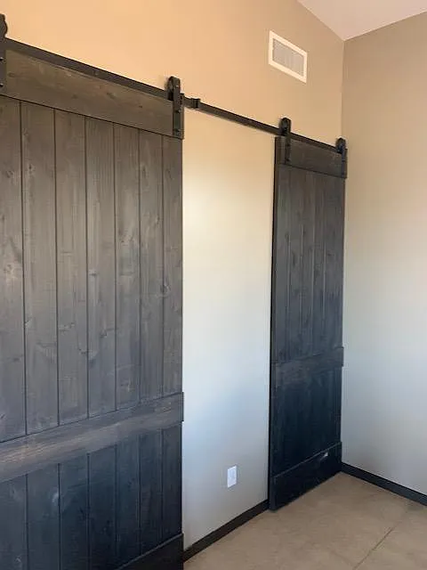 Barn doors in bedroom closing off the walk-in closet and bathroom. - 31724 N 168th St