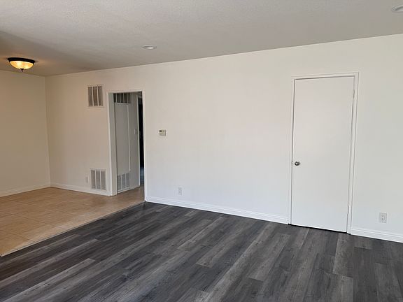 Living room with closet door, dining room and hallway to the bedroom and bathroom