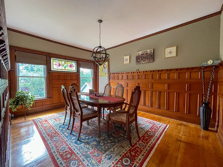 [Dining room] Features all-original wood paneling, and stained-glass window.