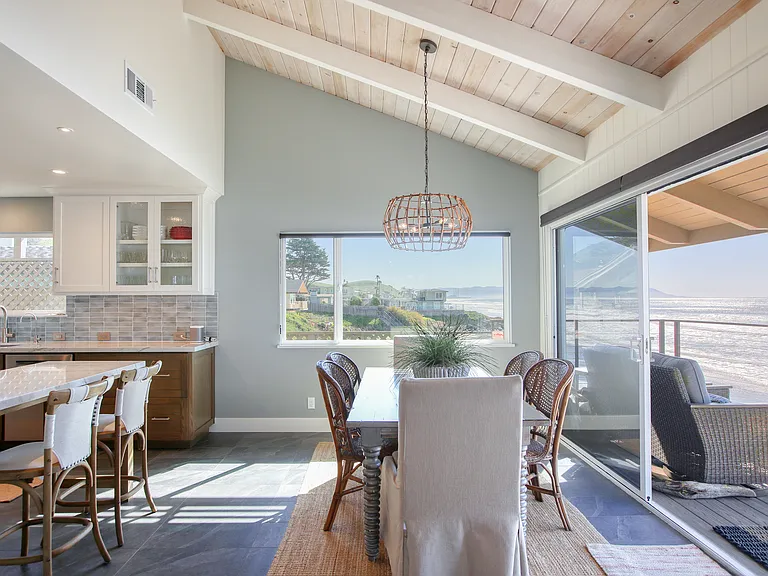Savor panoramic Pacific views from the open-concept kitchen and dining area. Vaulted ceilings and expansive windows bring the coastline inside, creating the ultimate backdrop for every meal.