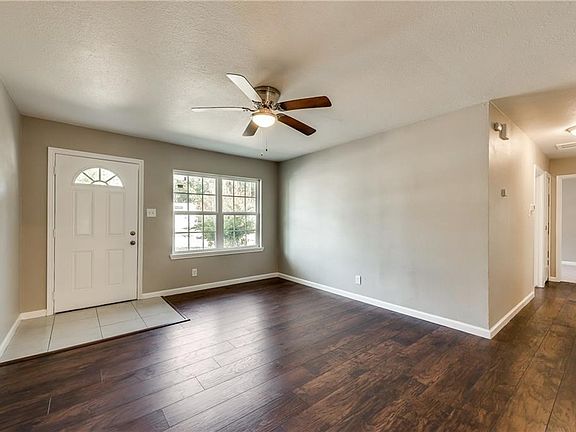 Living room features wood laminate floors, ceiling fan and all windows were replaced