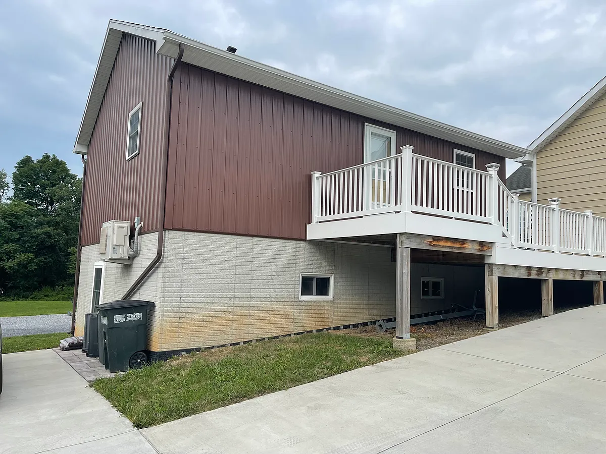 Apartment is up the stairs on the second floor (area with brown siding). Parking for one vehicle is on the concrete just left of the trash receptacles. Primary entrance is located on north side (as shown in picture), with second door on east side. - 506 Anderson Rd #1