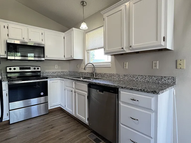 Kitchen with granite and stainless steel appliances, range, dishwasher and refrigerator with ice maker
