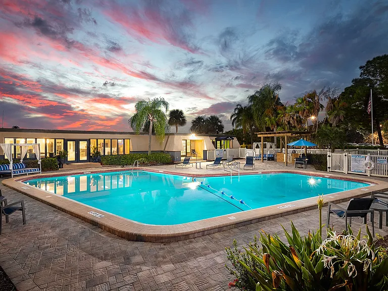 Resort style pool with lounge chairs and umbrellas