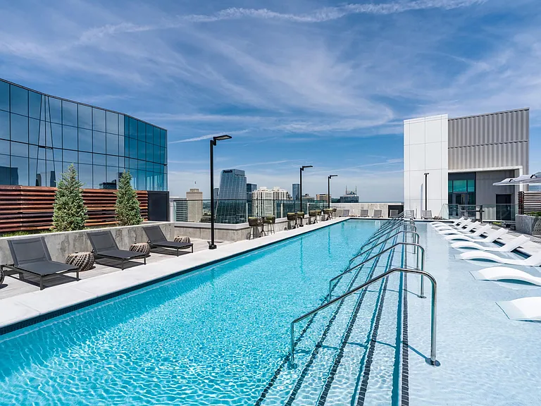 Rooftop pool with clear sightlines, in-water loungers, and surrounding city views creating a polished place to cool off and recharge.