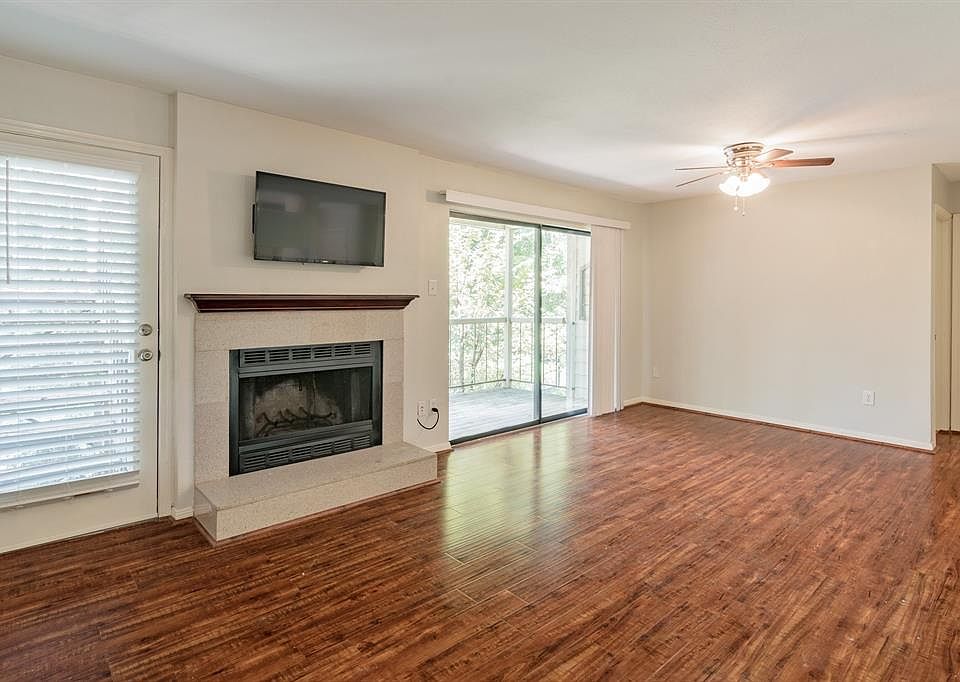 Rear stairs and entrance pictured on the left, fireplace and sliding glass doors to private balcony overlooking green space.