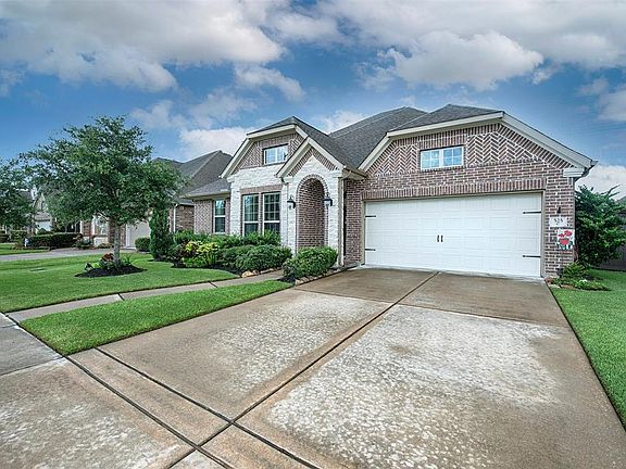 A view of the home showing the garage which is a 3 car tandem garage. Plenty of additional parking in the driveway for your guests when entertaining.