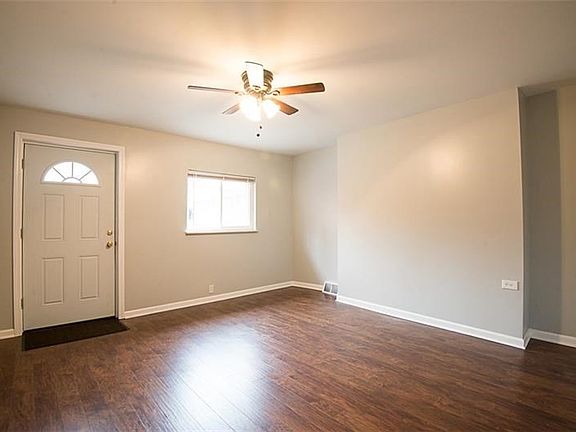 Bright living room new engineered wood flooring, neutral grey tones, and a new front door.