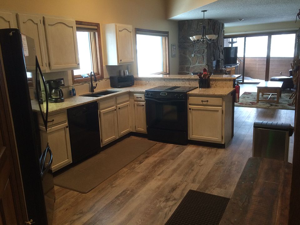 Kitchen and open space living area with sliding glass doors, deck and views of ski area.