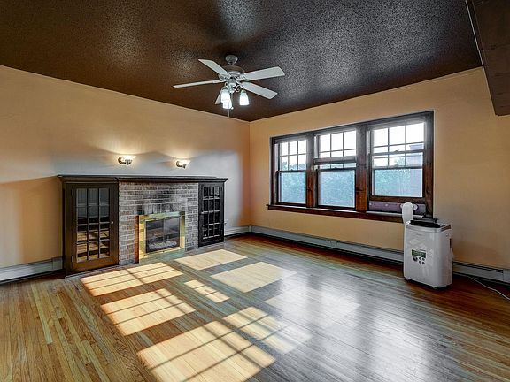 Living room with gas fireplace and eastern windows. Gas is included in rent. Floor air conditioner stays in rental unit and can easily be moved into the bedroom. Electricity is separate and the renter will need to set up an account with Xcel Energy.