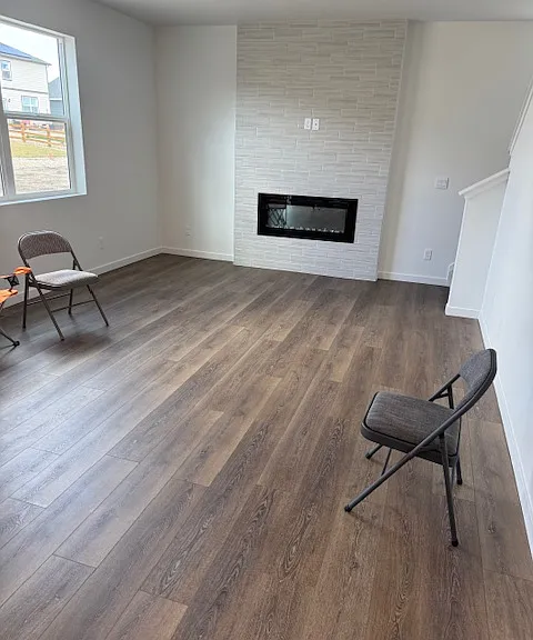 Open area great room (hall) with electric fireplace and beautiful wall decor for TV