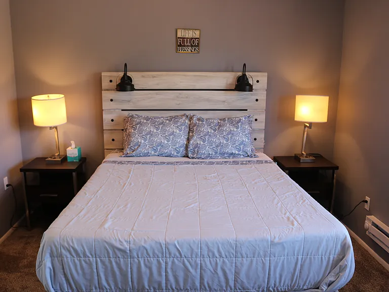 Master bedroom with nightstands. This queen bed has a memory foam mattress (medium soft). Linens provided, or bring your own.