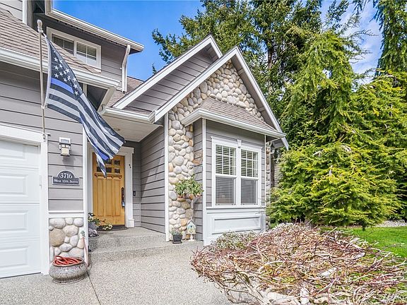 Front entrance to the home which features 3 car garage, and beautiful exterior finishes.  The large office/den is located to the right of the home as you enter where front window is located. 