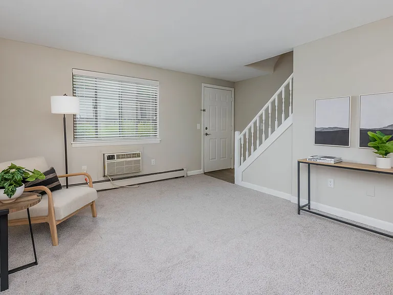 Discover townhome bliss in The Sycamore, with a roomy living room, plush carpeting, and a bright, airy ambiance.