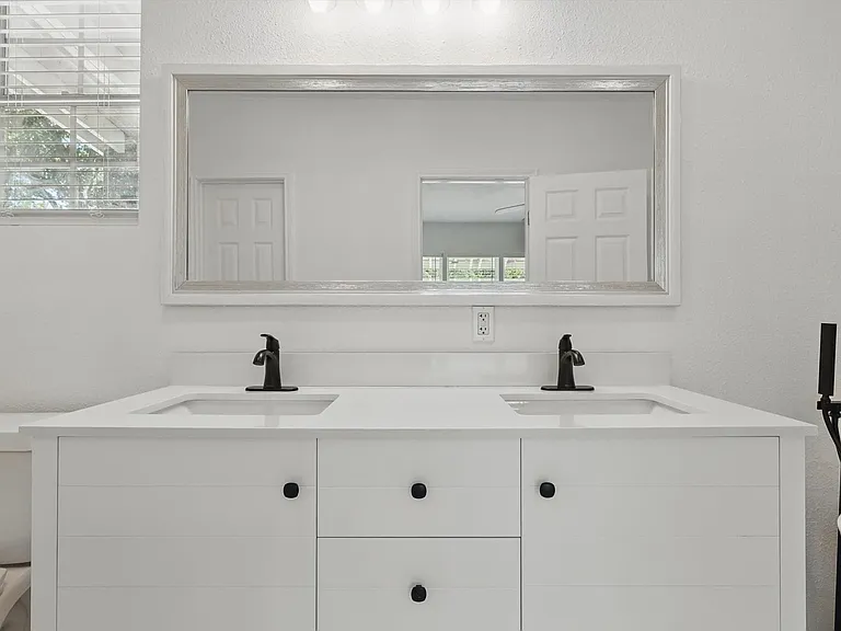 Bathroom featuring toilet, double vanity, and healthy amount of natural light