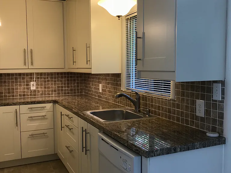 Kitchen features granite countertops, tile backsplash, LOTS of storage, dishwasher, (Microwave over gas stove, fridge also, not shown in this picture) under cabinet lighting too