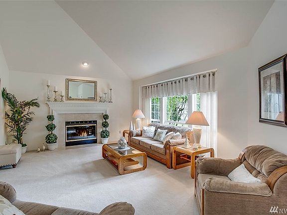 This formal living room also features soaring vaulted ceilings plus a wall of windows and cozy fireplace.