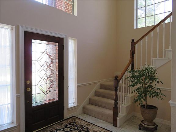 Grand 2 Story Entry Foyer with Marble Tile Floors. Entry is 12 x 10 Feet with wrap around stair case to the upper level.