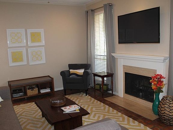 Living room with wood burning fireplace and recessed lightin