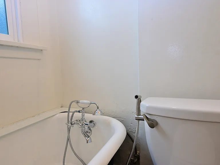 upgraded bathroom with new tiled floor, repainted claw foot tub + new bathroom hardware + new bathroom vanity cabinet+new mirror + handheld bidet