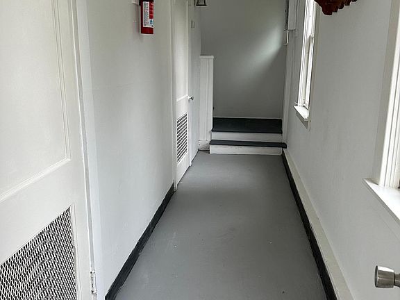 Private hallway from entrance leading the stairs to the apartment; washer and dryer are behind 2nd door on the left