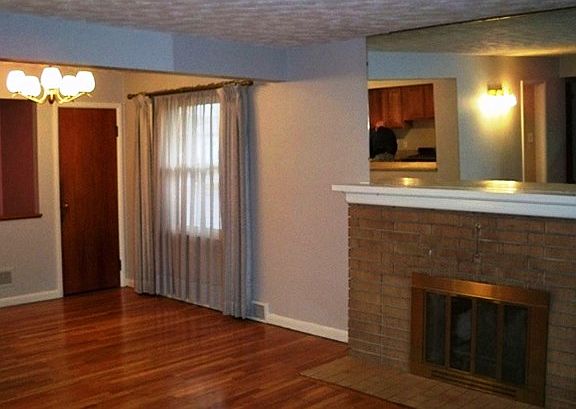 Looking towards the dining room the living room has a wood burning fireplace.