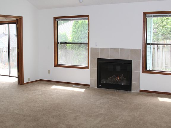 Living room with new gas fireplace. Room on left (where you see the large opening on the left) is the 3rd bedroom or office/den. 3rd bedroom or office has a normal door entry from the hallway, this larger entry from the living room (in photo), as well a