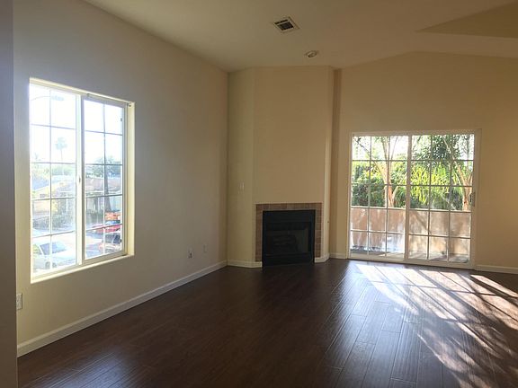 Bright living room with high ceilings, fireplace and balcony access