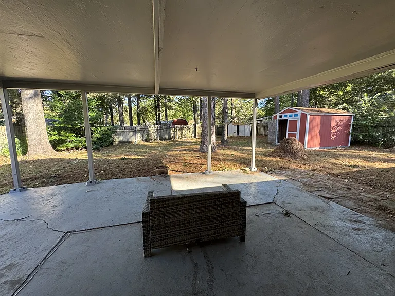Fenced in backyard with covered patio