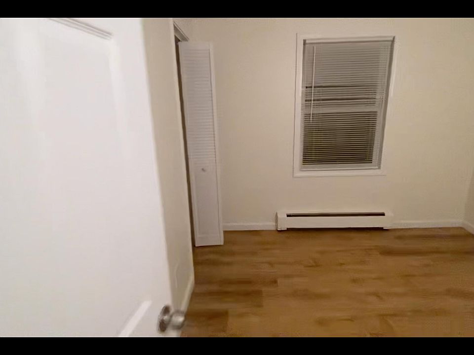 This photo shows the smaller of the 2 bedrooms. It has one window and a closet.