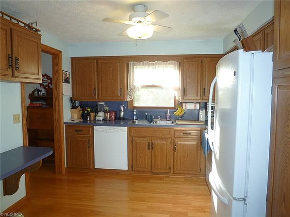 KITCHEN OFFERS DISHWASHER, SNACK BAR, STOVE, PANTRY, CEILING FAN AND NEWER HICKORY WOOD FLOORS