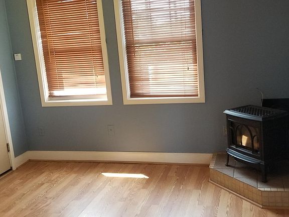 Jotul propane heat in living room area; ceiling fan in rea. Photo shows emergency exit door. Renter has a private access door to unit.