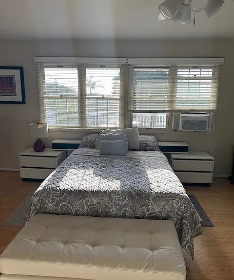 Queen bed with built ins, window air conditioner, ceiling fan.