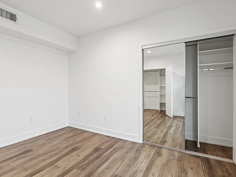 Bedroom with Mirrored Closet and Vinyl Flooring