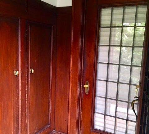 Entrance with vintage wood panelling and built-in coat closets.