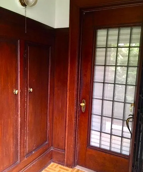 Entrance with vintage wood panelling and built-in coat closets.