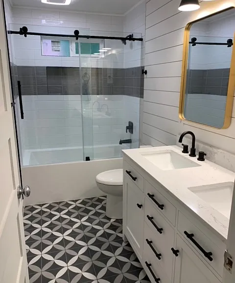 Remodeled and updated full bath with dual-sink vanity.