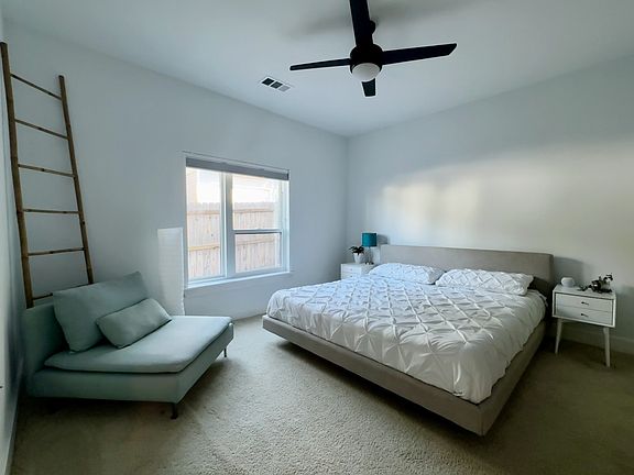 Peaceful bedroom with blackout shade, walk-in closet, and soft natural light.