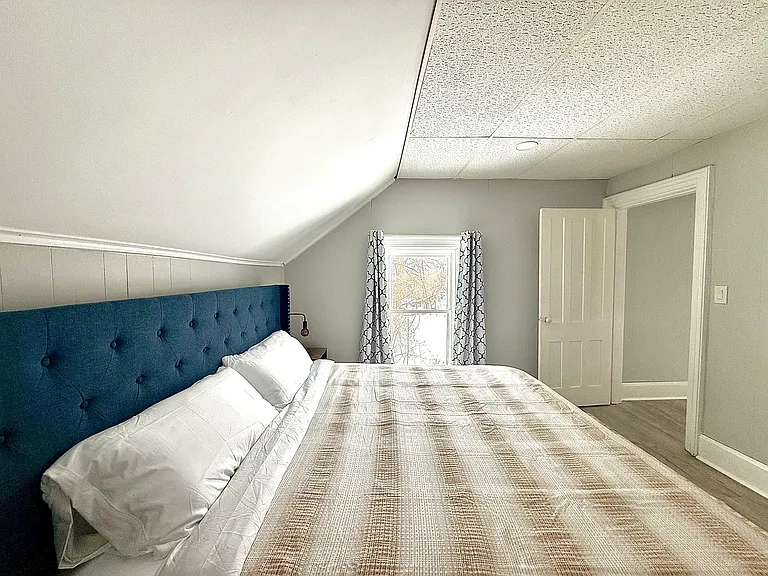 The secondary bedroom offers a king-size bed and an abundance of natural light, along with black-out shades to ensure a peaceful and restful atmosphere.