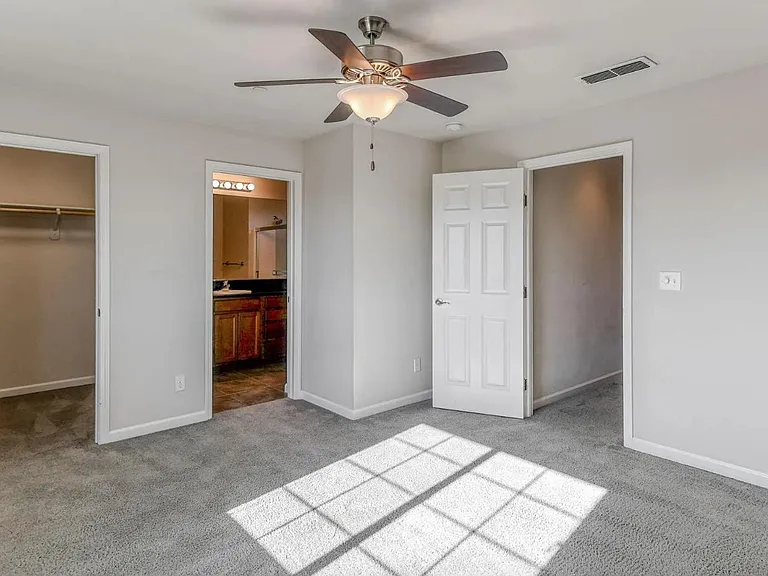 Primary bedroom with new carpet, walk in closet, private bath with updated fixtures, and granite countertops.
