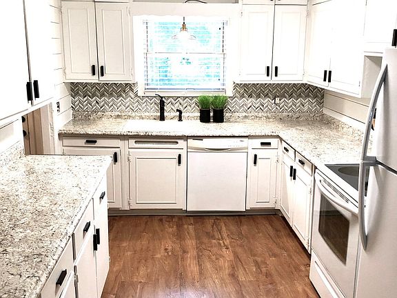 Large renovated kitchen with glass tile backsplash and shiplap walls. New appliances.
