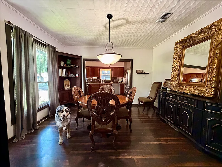 Dining area featuring wood-finish flooring, a decorative ceiling with a central fixture, and a built-in corner cabinet