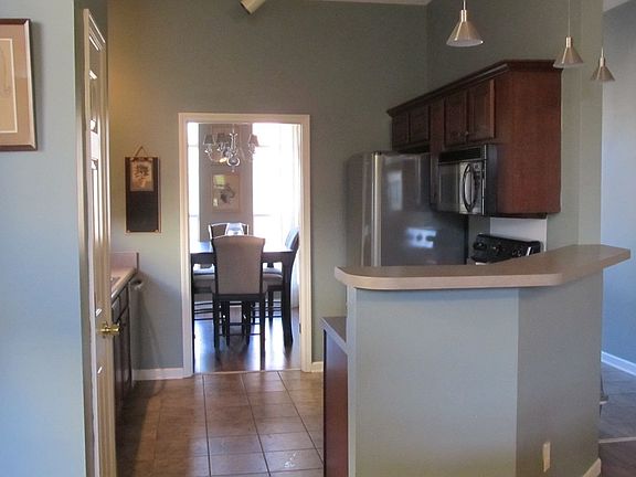 Kitchen has stainless applicances, breakfast bar, pantry, tile floors.