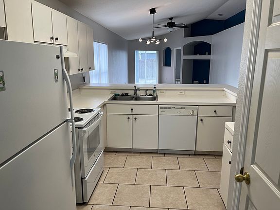 Kitchen view, pantry closet door on right.