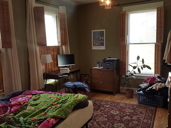 Bedroom with 10' ceiling, 3 large windows, interior wooden shutters, hardwood floors, and large closet (not shown)