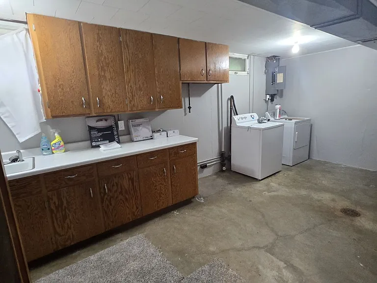 washer & dryer / sink area/ storage in basement