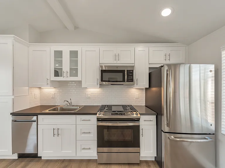 Updated kitchen featuring quartz countertops, stainless steel appliances, and generous storage / large pantry.