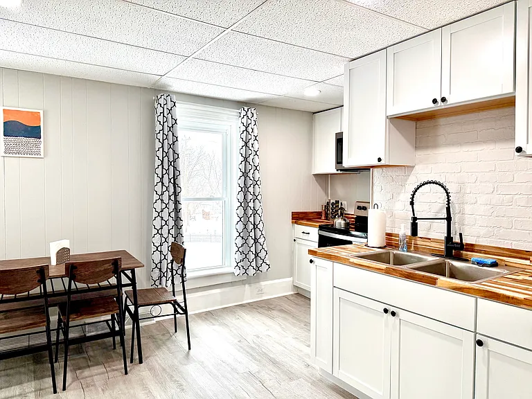 This bright and airy kitchen is filled with natural light, highlighting the beautiful shaker cabinets that offer plenty of storage space. The modern pull-out faucet adds a stylish touch, making this kitchen both functional and inviting.