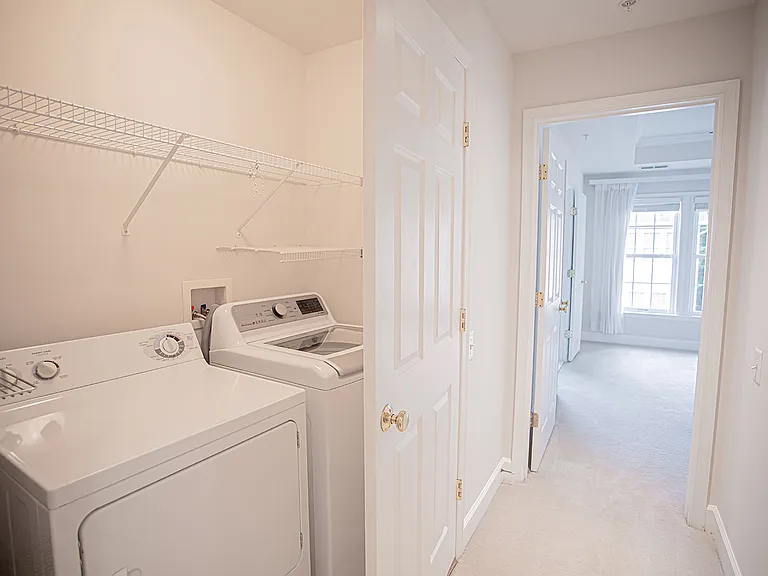 Laundry room conveniently located next to bedrooms, featuring newer washing machine