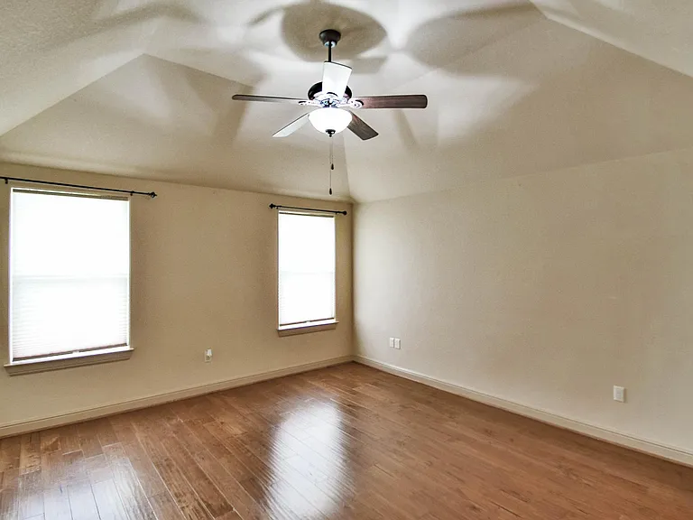Primary bedroom with wood flooring